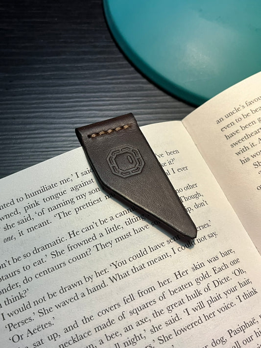 Leather bookmark with a brand logo on an open book