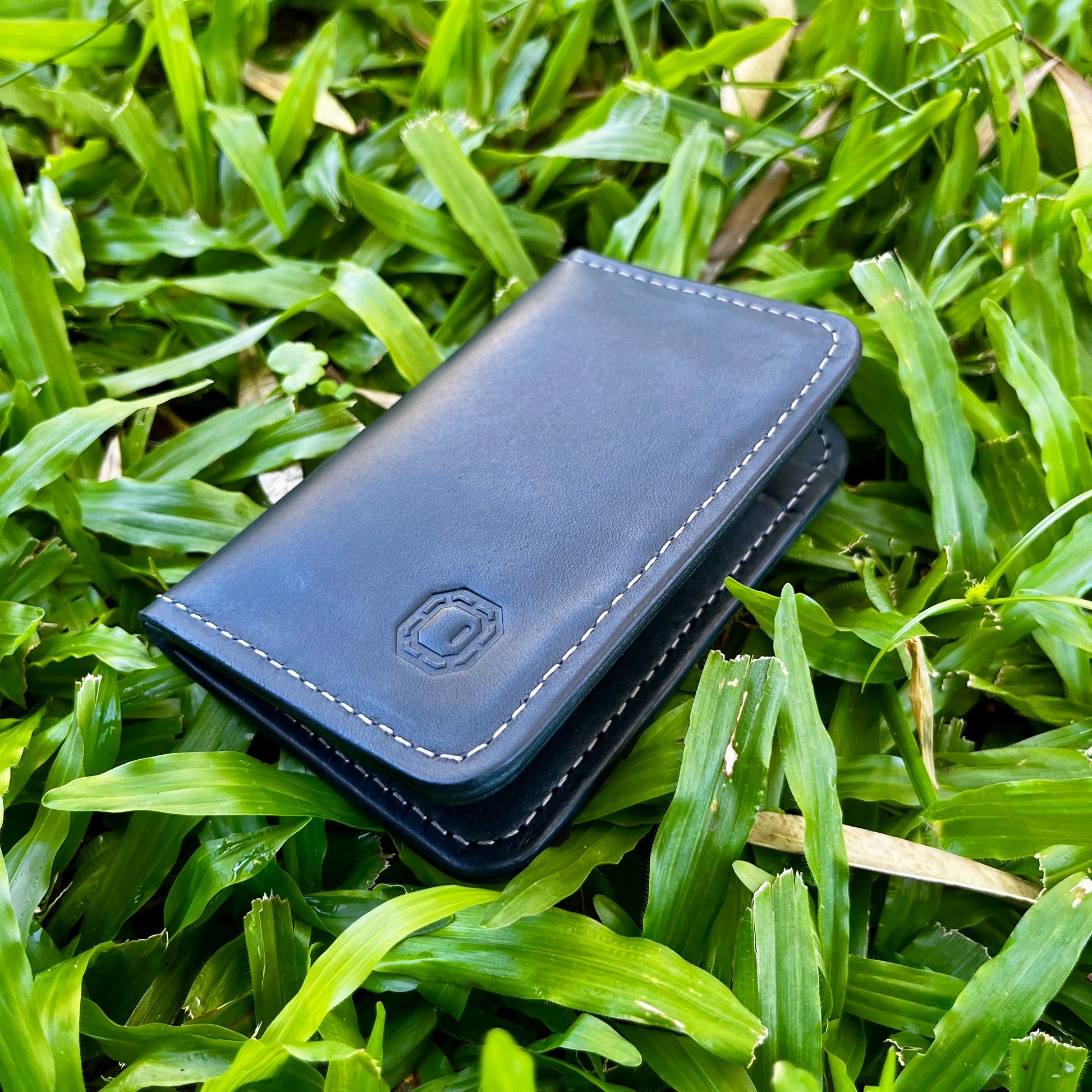 Navy leather wallet on grass