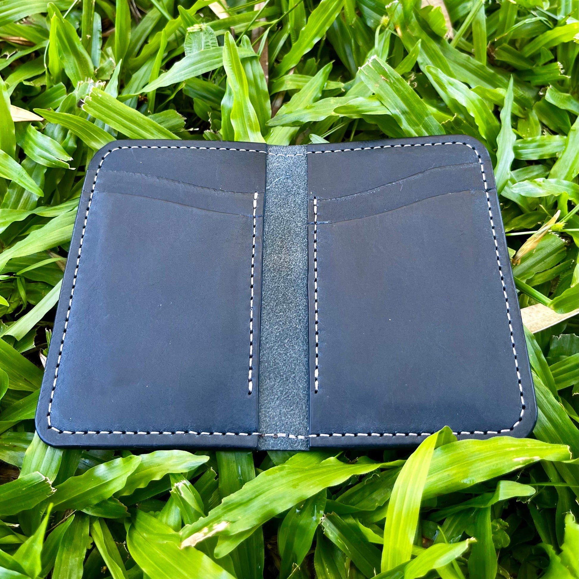 Navy leather wallet on grass
