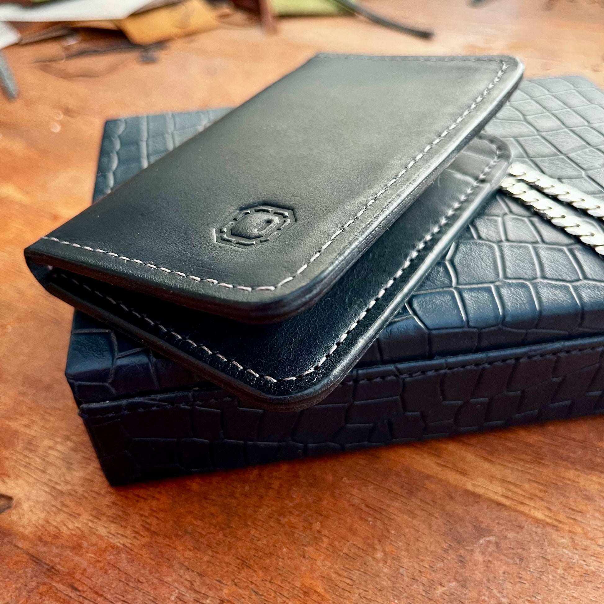 Navy leather wallet on a crocodile texture on a wooden surface