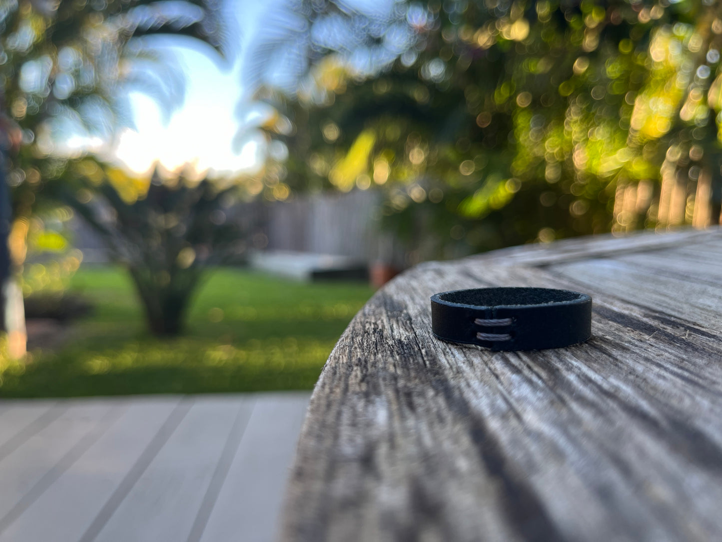 Close-up of a Navy Minerva ring on a wooden surface with a blurred outdoor background
