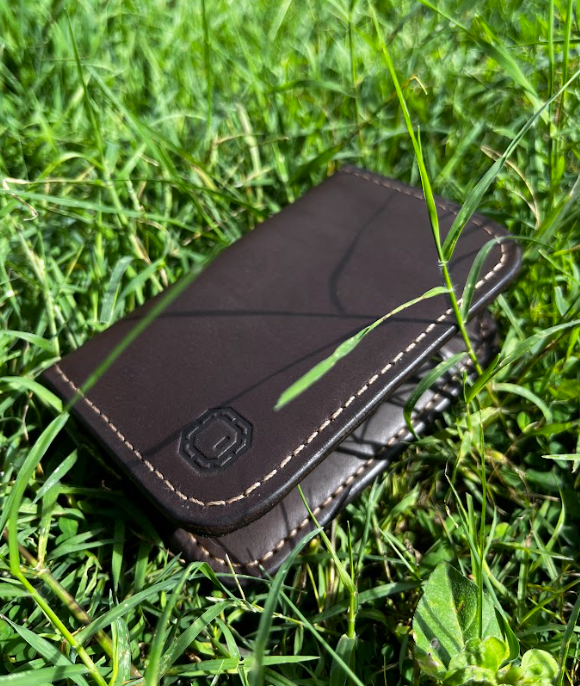 Brown leather wallet on grass