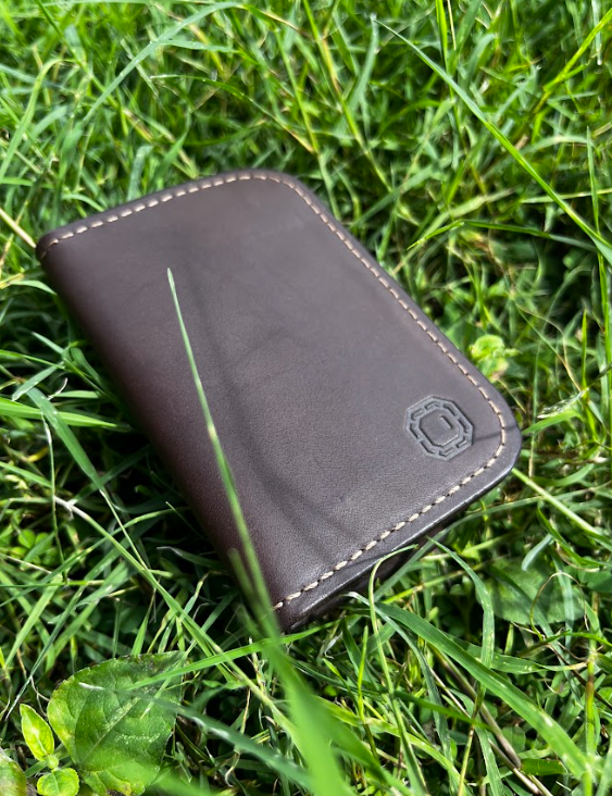 Brown leather wallet on grass
